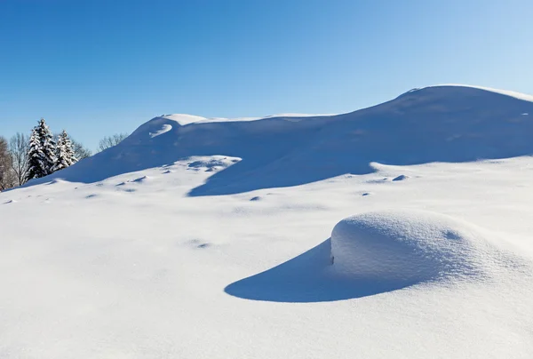 Deserted winter hilly field landscape with beautiful shadows — Stock Photo, Image