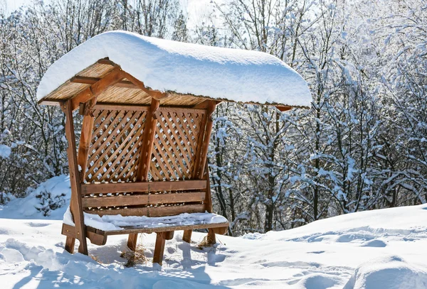 Wooden awning bench covered by hard snow — Stock Photo, Image