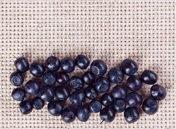 Many bilberry fruits, on gray linen table cloth with copy space — Stock Photo, Image