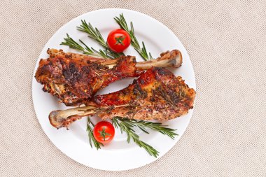 kiraz domates ve rosema ile beyaz tabakta kavrulmuş hindi budu