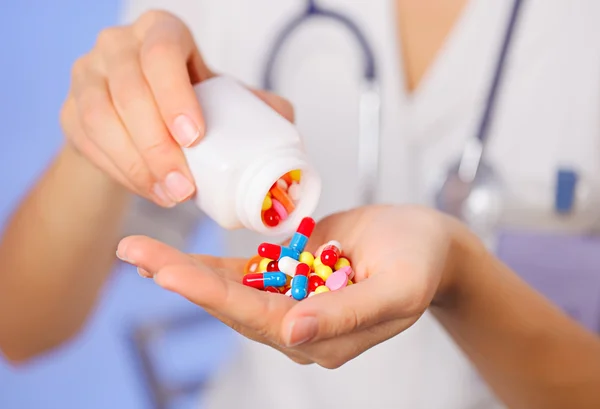 Pills, tablets and drugs pouring from bottle in doctor's hand on — Stock Photo, Image