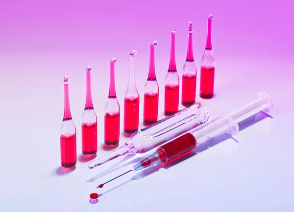 Red Ampules and syringe still life in vivid colors — Stock Photo, Image