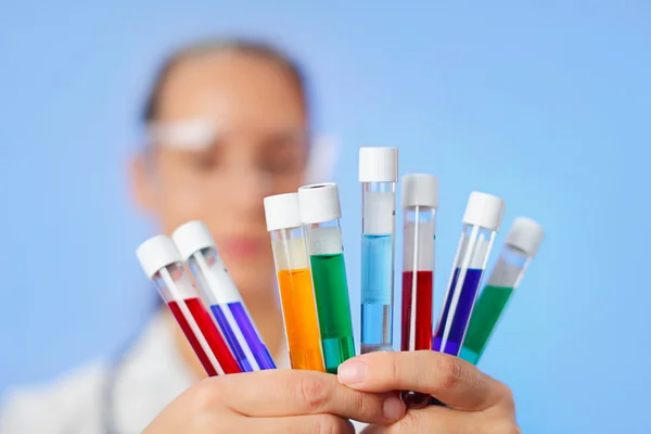 Tubes à essai multicolores médicaux avec échantillon de liquide dans les mains du médecin — Photo