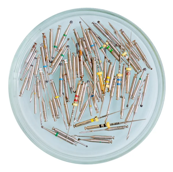 Muitas brocas dentárias em copo de vidro isolado em branco — Fotografia de Stock