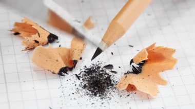 kare kağıt arka plan üzerinde bir çakı ile kalem keskinleştirmek