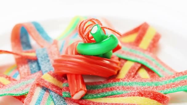 Colorful gummy candy (licorice) rotating on a white plate — Stock Video