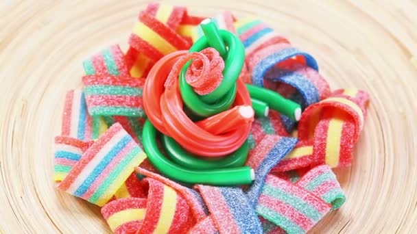 Multicolor gummy snoep (drop) draaien op een houten bord — Stockvideo