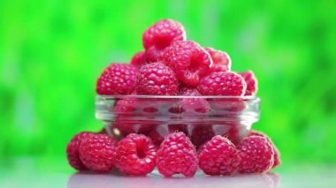 Açık yeşil arka plan üzerinde dönen ahududu meyve yığın