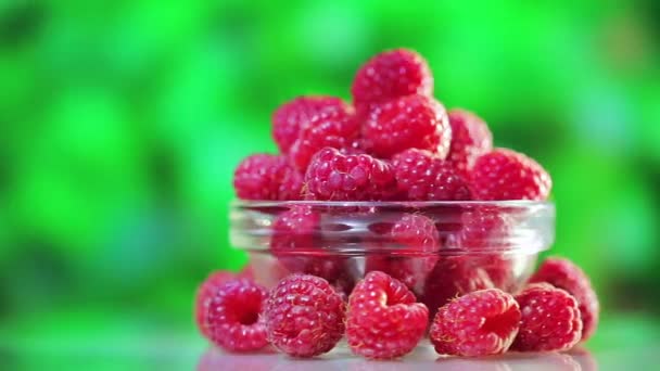 Raspberry vruchten heap draaien op groene buiten achtergrond — Stockvideo