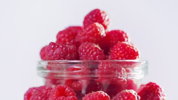 Montón de fruta de frambuesa girando sobre fondo blanco — Vídeo de stock