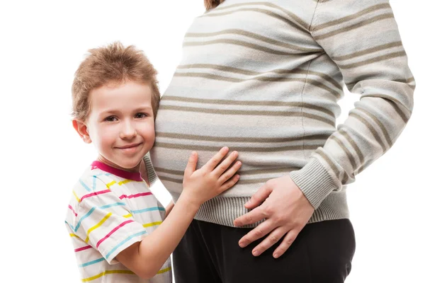 Pequeño hijo tocando o uniendo su abdomen madre embarazada — Foto de Stock