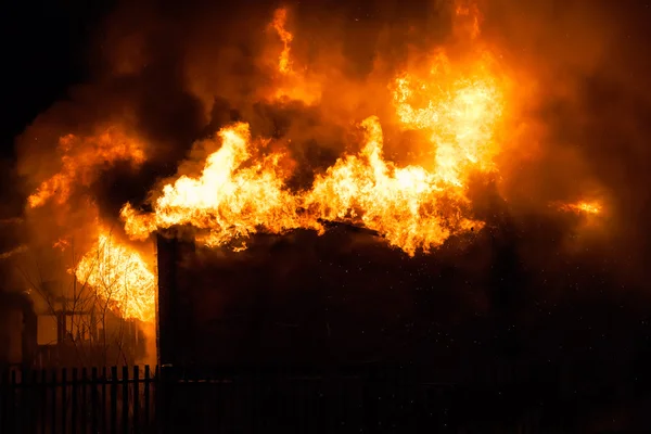 Burning fire flame on wooden house roof — Stock Photo, Image