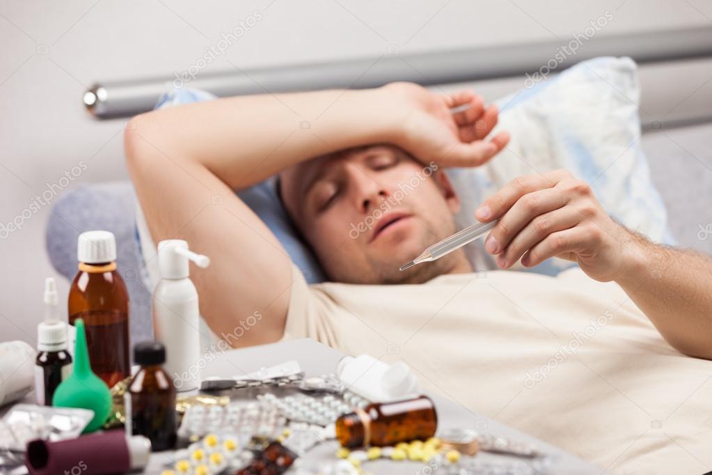 Unwell man patient lying down bed — Stock Photo © ia__64 #26332811
