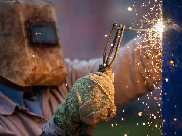 Soldador de arco trabalhador em máscara protetora soldagem construção de metal — Fotografia de Stock