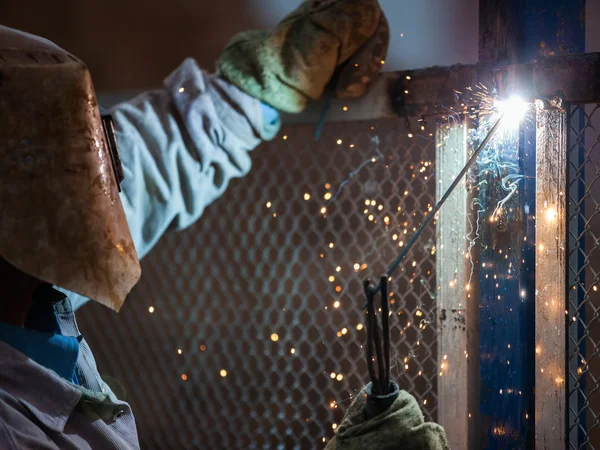 Arc welder worker in protective mask welding metal construction — Stock Photo, Image