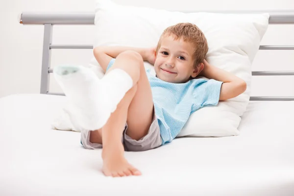 Petit enfant garçon avec bandage de plâtre sur la fracture du talon de la jambe ou br — Photo