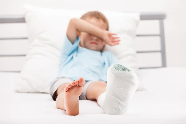 Chłopiec dziecko z bandażem gipsu noga pięta pęknięcie lub br — Zdjęcie stockowe