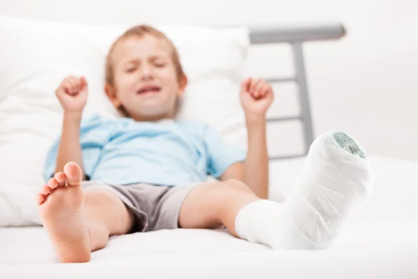 Petit enfant garçon avec bandage de plâtre sur la fracture du talon de la jambe ou br — Photo