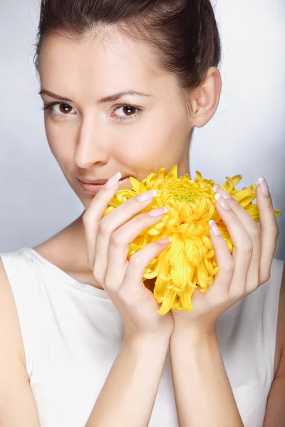 Vacker ung kvinna håller blomma — Stockfoto