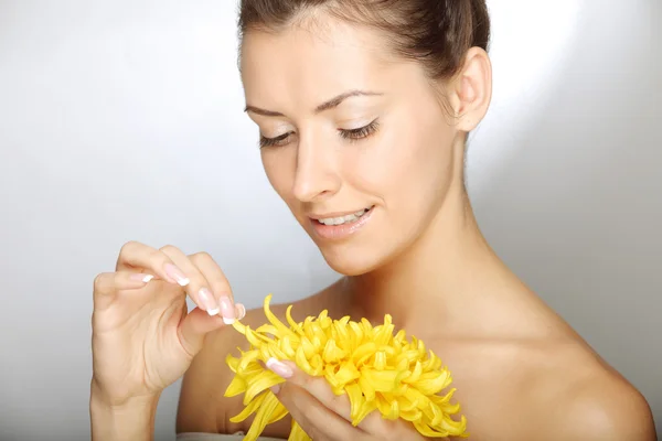 Mooie jonge vrouw met bloem — Stockfoto