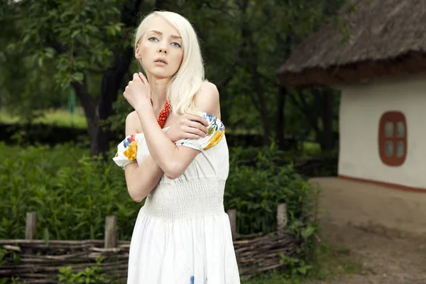 Rural woman standing by old house — Stock Photo, Image