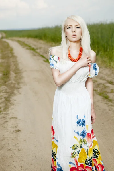 Rural woman standing on the road by the field — Stock Photo, Image
