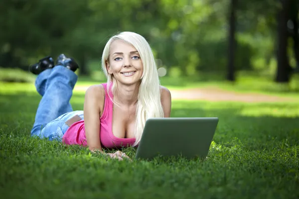 Beautiful young blond woman sitting outdoor — Stock Photo, Image