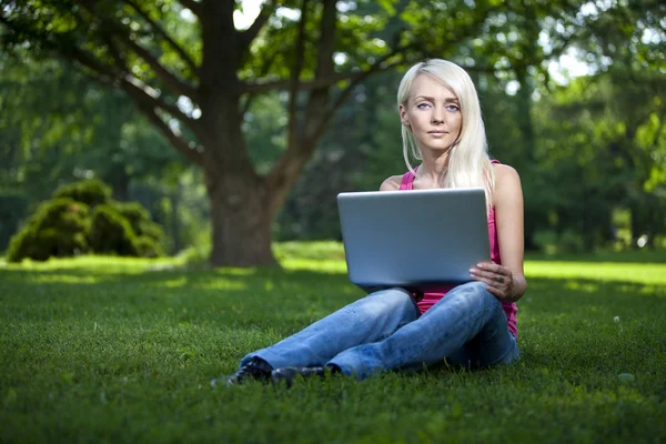 Beautiful young blond woman sitting outdoor — Stock Photo, Image