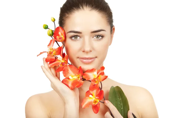 Vacker brunett kvinna håller gren av orkidé — Stockfoto