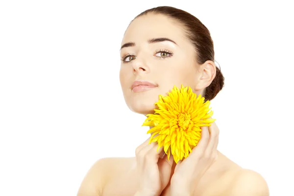 Mooie brunette vrouw met gele bloem — Stockfoto