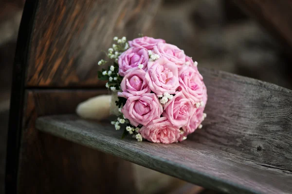 Brud bukett med rosa rosor på träbänk — Stockfoto