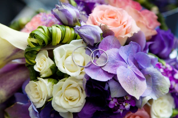 Due fedi nuziali su bouquet da sposa — Foto Stock