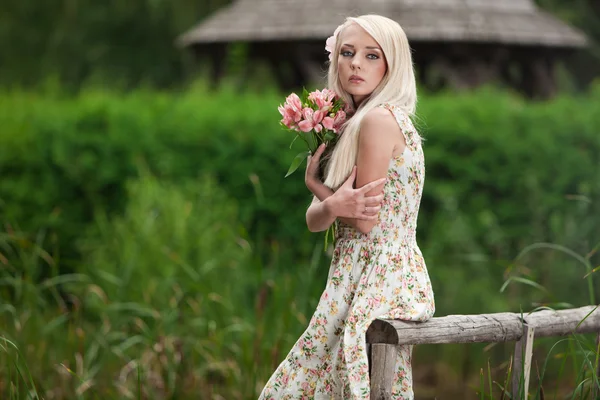Ung kvinna som håller bukett blommor — Stockfoto