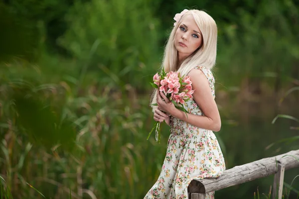 Young woman holding bouquet of flowers — Stock Photo, Image