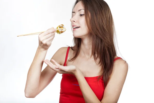 Beautiful brunette woman eating sushi — Stock Photo, Image