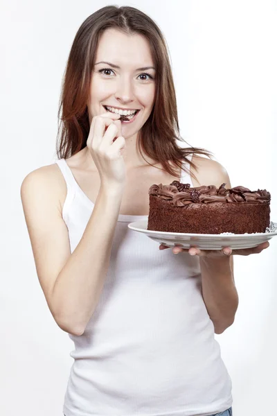 チョコレート ケーキを食べて美しいブルネットの女性 — ストック写真