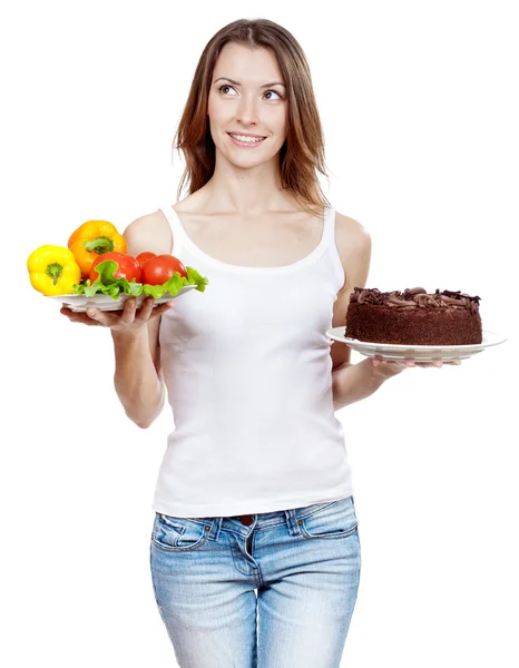 Choice between vegetables and chocolate cake — Stock Photo, Image