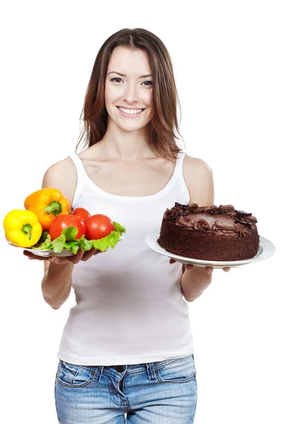 Making hard choice between vegetables and cake — Stock Photo, Image