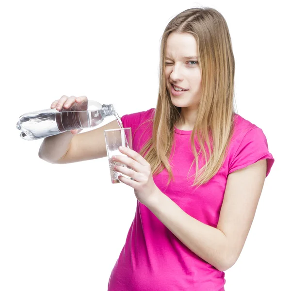 Young beautiful woman pours water into a glass — Stock Photo, Image