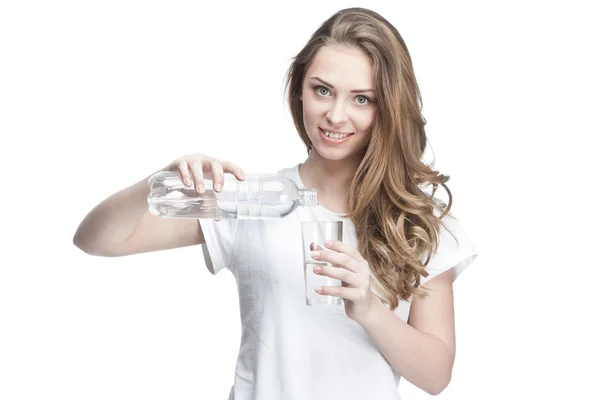 Young beautiful brunette pours water — Stock Photo, Image