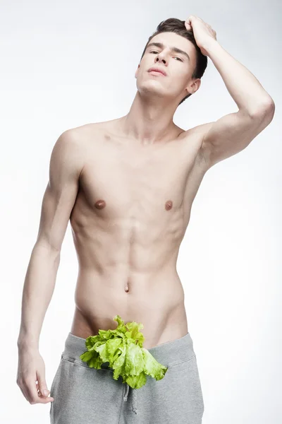 Jovem sem camisa com salada nas calças — Fotografia de Stock