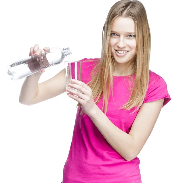 Giovane bella donna versa l'acqua in un bicchiere — Foto Stock
