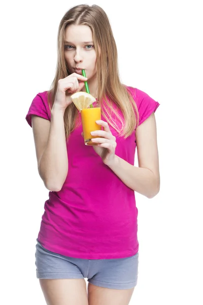Молодая красивая блондинка пьет апельсиновый сок — стоковое фото