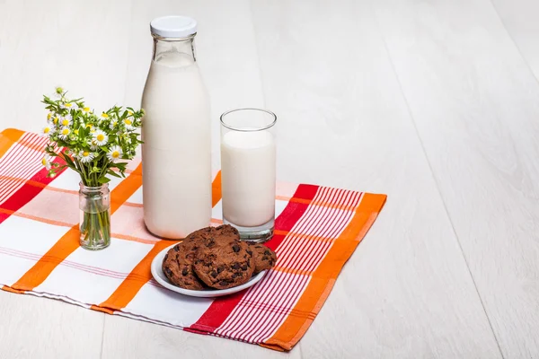 Milk bottle and glass on wooden background — Stock Photo, Image