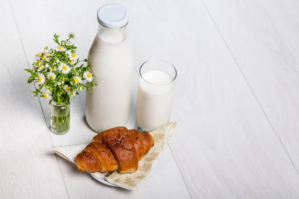 Milk bottle and glass on wooden background — Stock Photo, Image