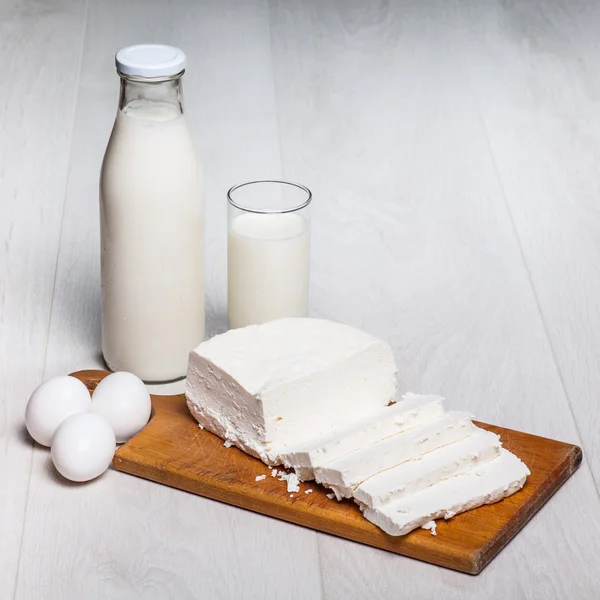 Milk bottle and glass on wooden background — Stock Photo, Image