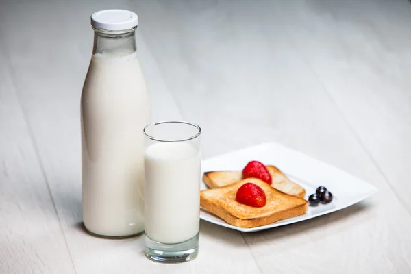 Milk bottle and glass with toasts — Stock Photo, Image