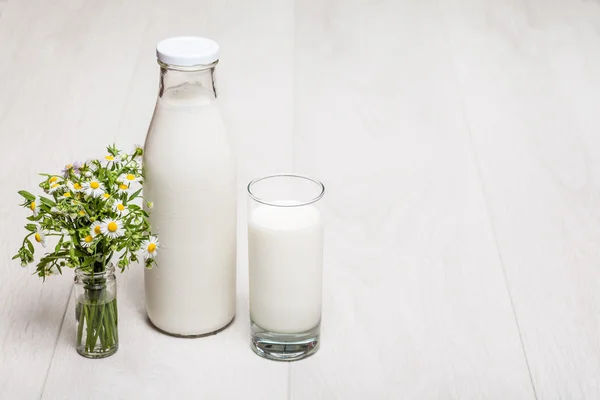 Botella de leche y vidrio sobre fondo de madera — Foto de Stock