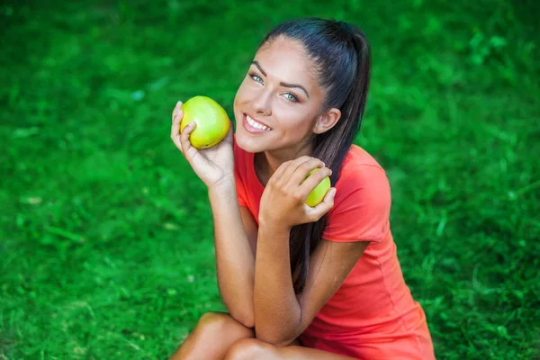 Young beautiful brunette woman holding two apples — Stock Photo, Image