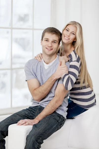 Happy young caucasian couple sitting on couch — 图库照片